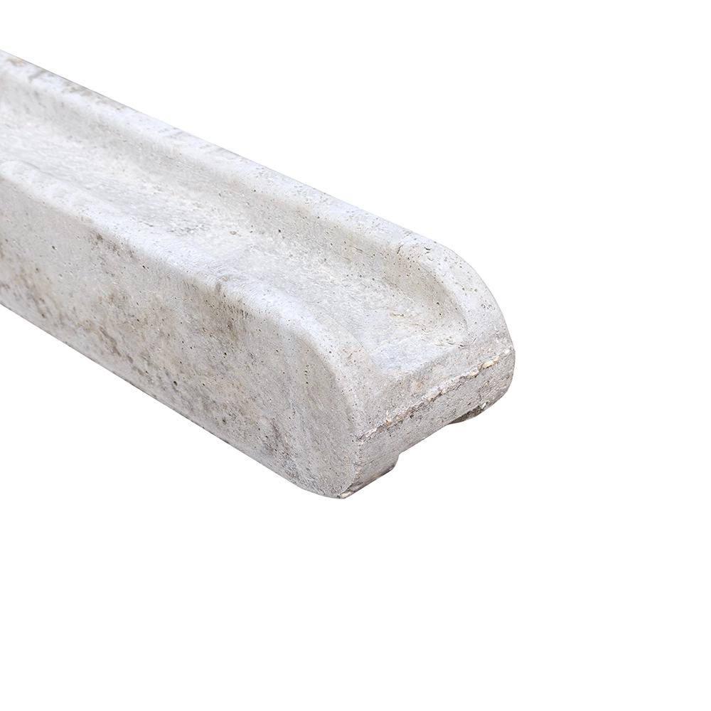 A close up of the rounded top of a concrete slotted post against a white background