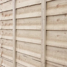 A close up angled view of a green pressure treated timber lap panel.