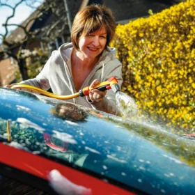 The Hozelock Jet Spray Gun being used to clean the front windshield of a card