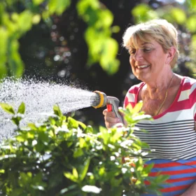 The Hozelock Multi Plus Spray Gun being used to water some bushes in a garden