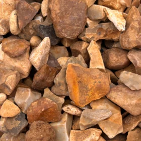 Close-up of golden gravel 20mm decorative aggregate showing a mix of angular and rounded stones in warm tones of gold, brown, cream, and ochre.