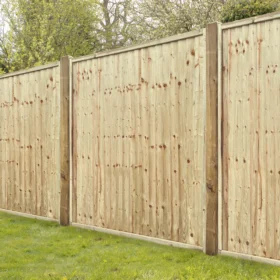 Closeboard fence panels installed in a garden, showing framed timber panels with overlapping vertical boards providing strong, private boundary fencing.